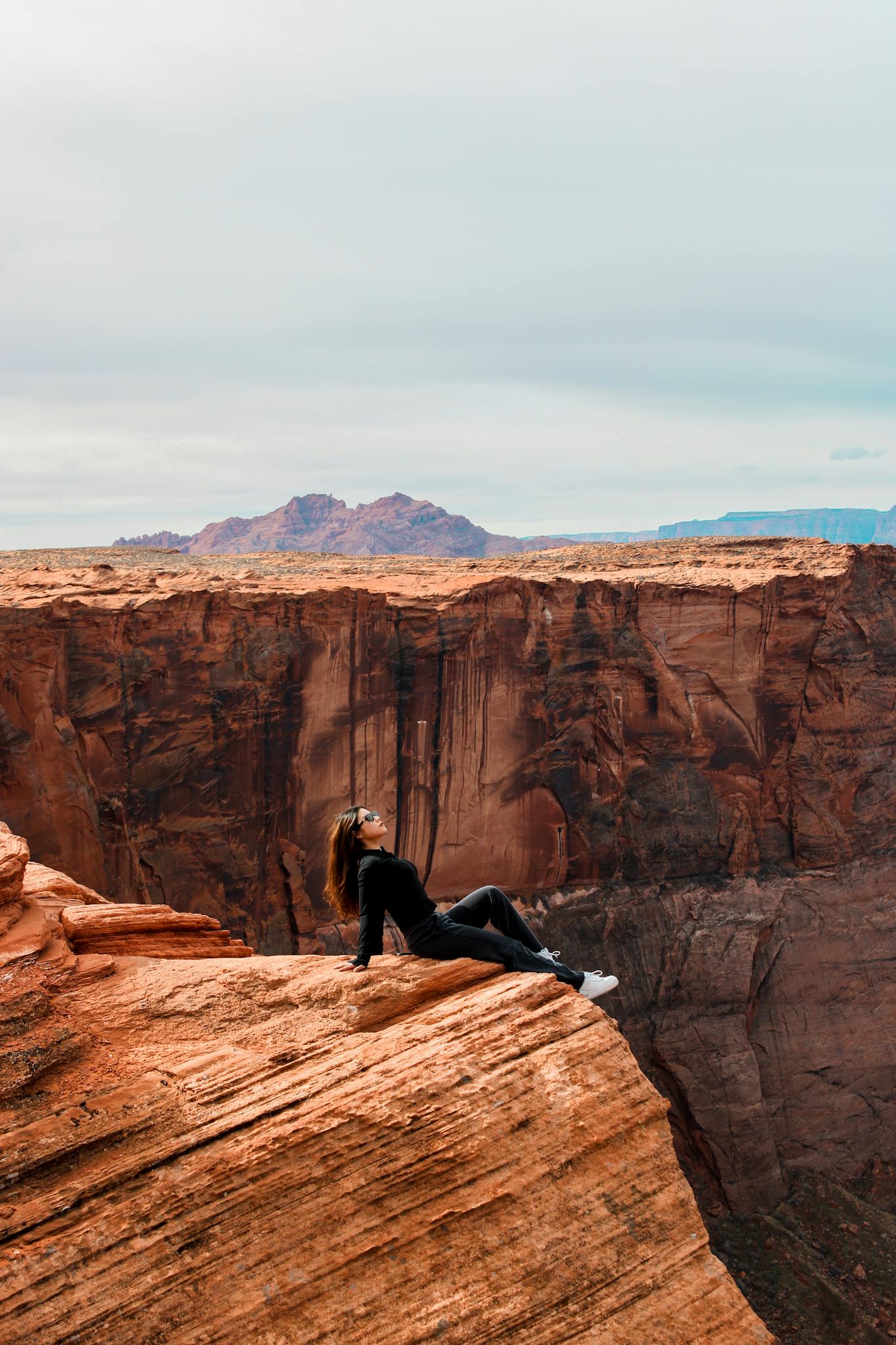 A woman enjoying the scenic view from Horseshoe Bend in Arizona, USA.